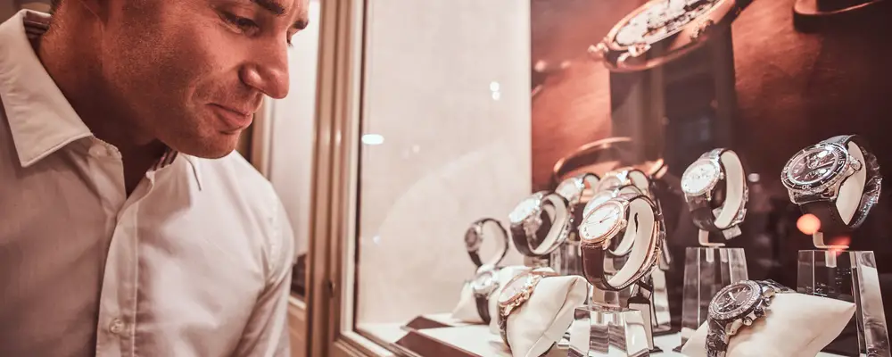 Man looking at a showcase with an exclusive men's watches in a luxury jewelry store