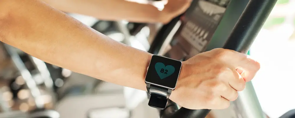 Smart watch showing a heart rate of excercising woman in gym