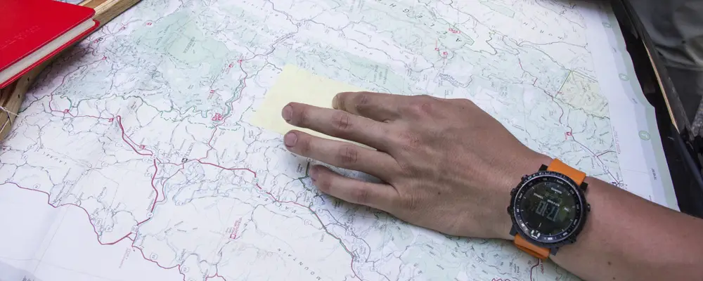 Man with wristwatch using map